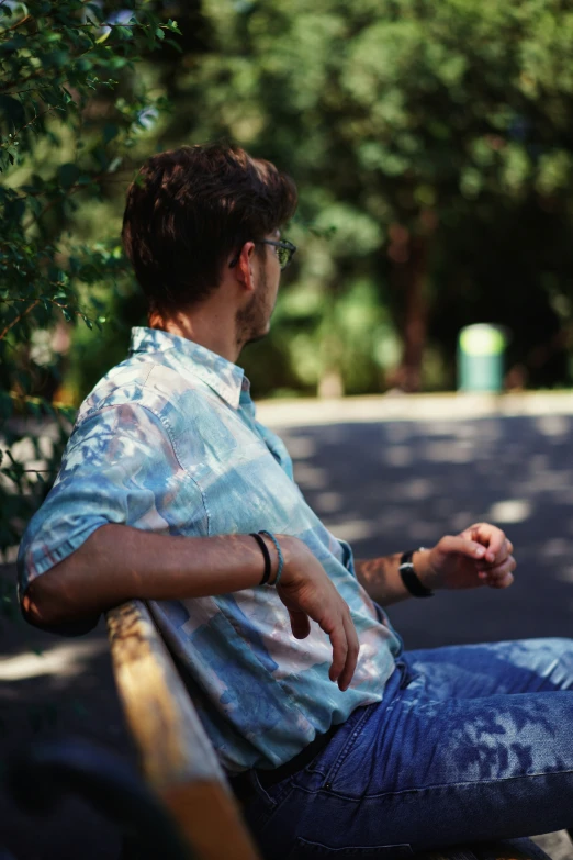 man sitting down on a bench with his hand out and the other side of his body