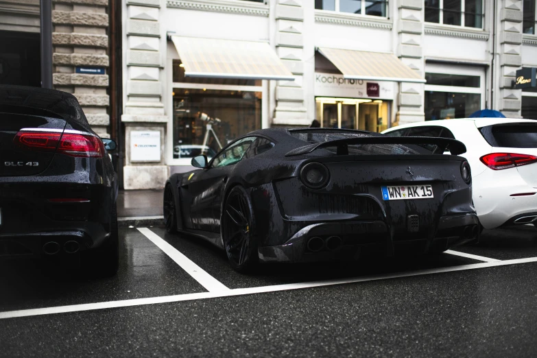 cars parked in a parking space next to tall buildings