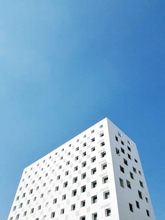 a tall white building with several balconies and windows