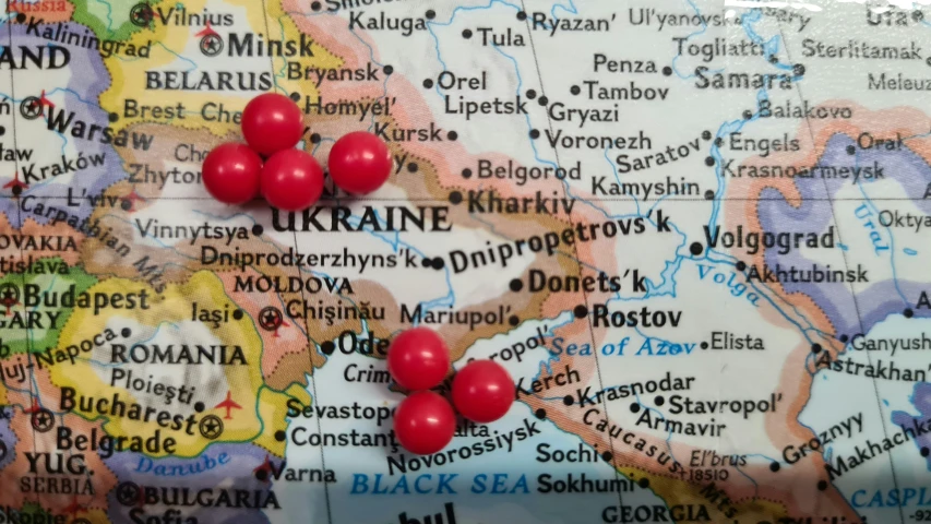 a map with h pins in ukraine and three red balls