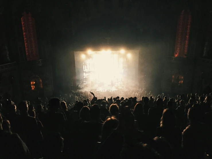 an audience in front of a stage at a concert