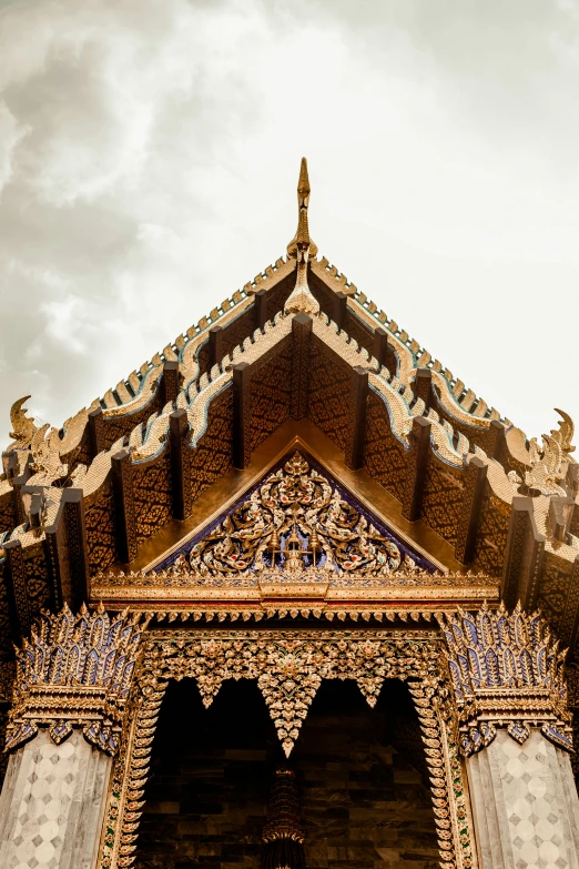 a small golden building sitting under a cloudy sky