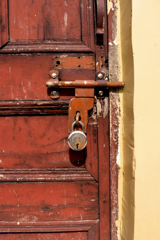 this door has a padlock on it and is red