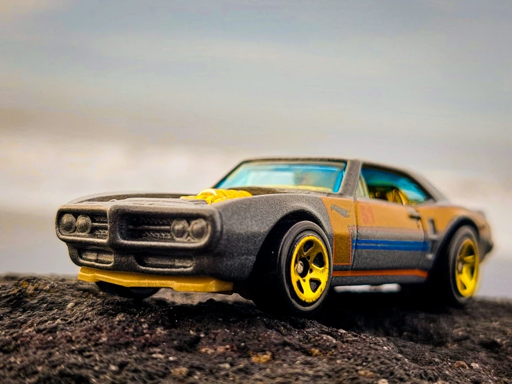 a toy car is standing in the dirt