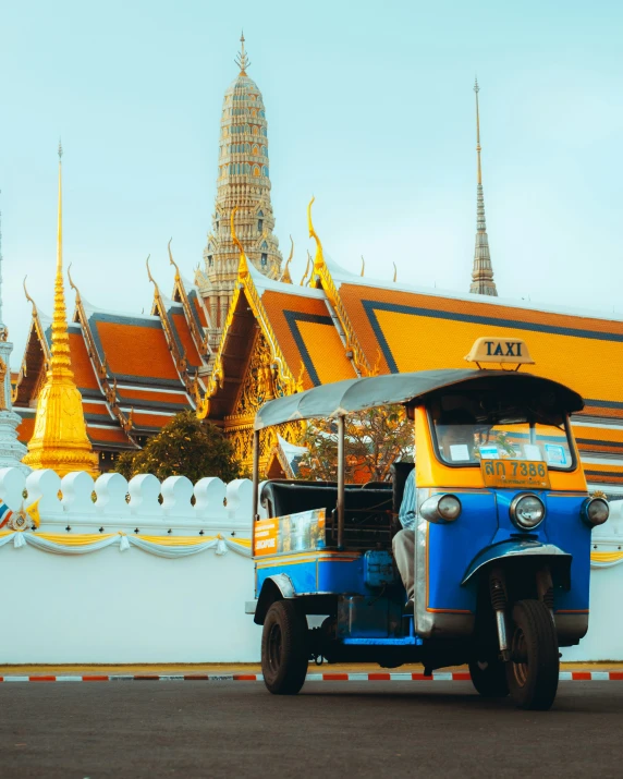 an old jeep is parked in front of a buddhist temple