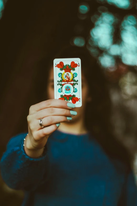 the woman is holding up a card to take her picture