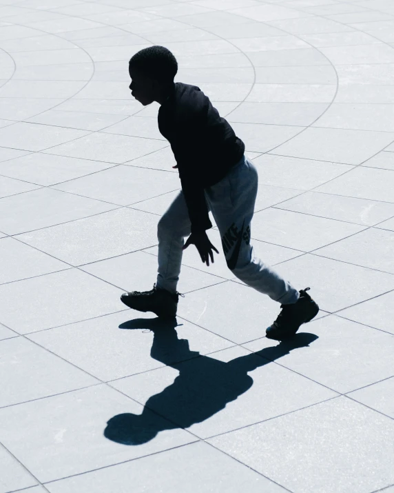 a person wearing a backpack is walking on tiled pavement