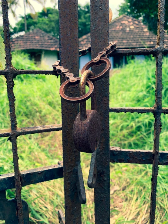 rusty gated in with key hanging from it