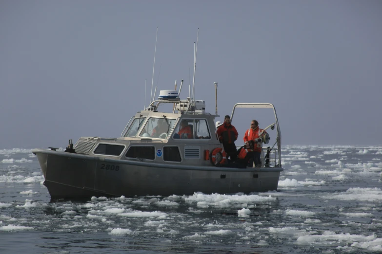 the two men are riding in the grey boat