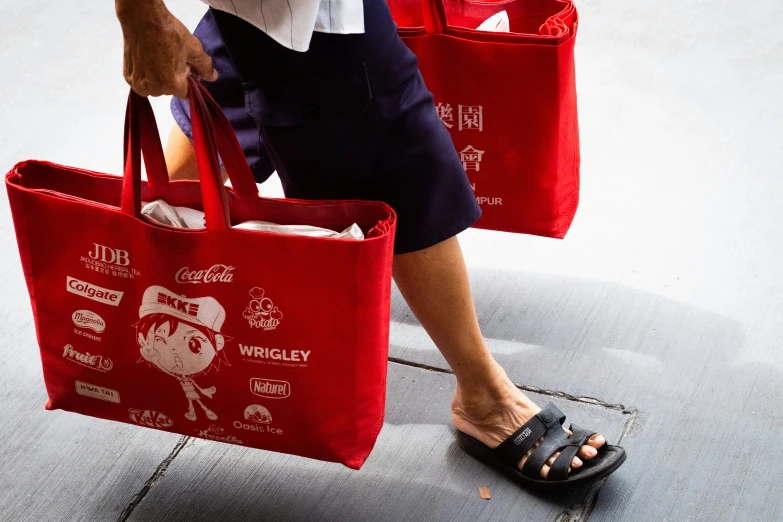 woman carrying two red bags that are open