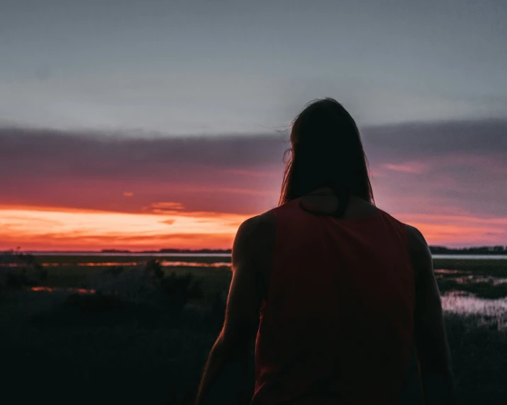 a woman standing on top of a hill looking at the sky