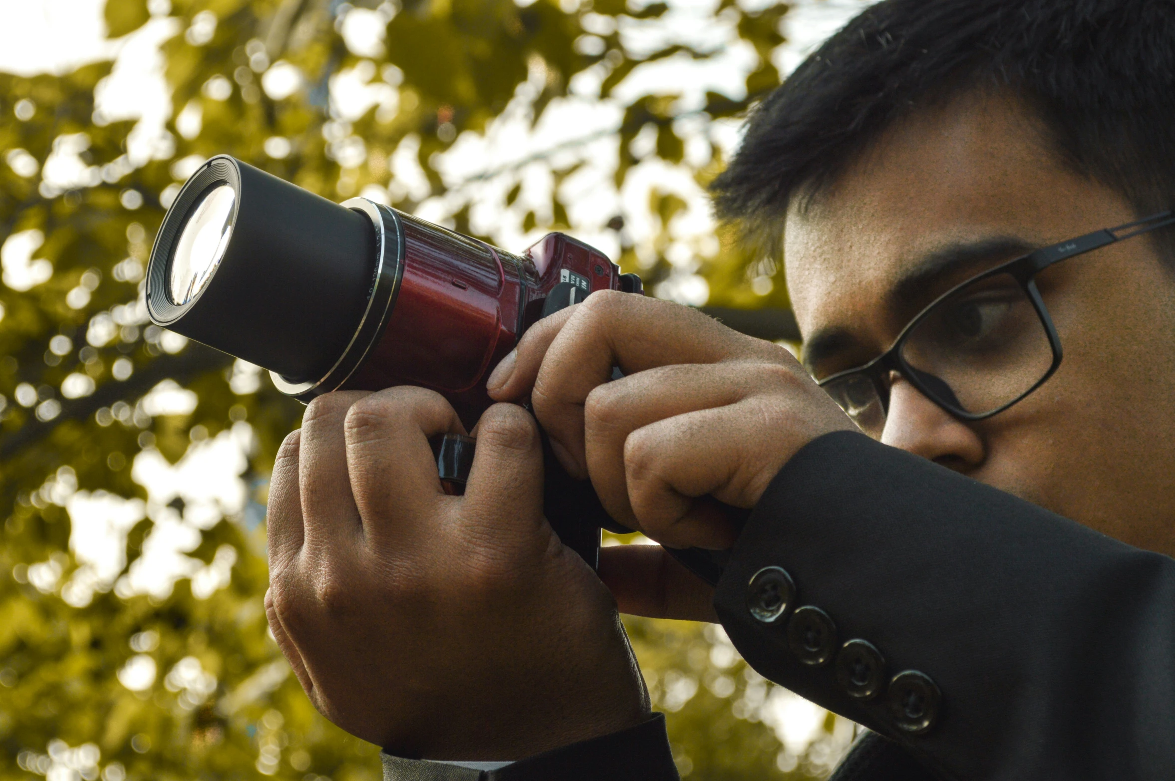 man holding a camera taking pictures with a lens