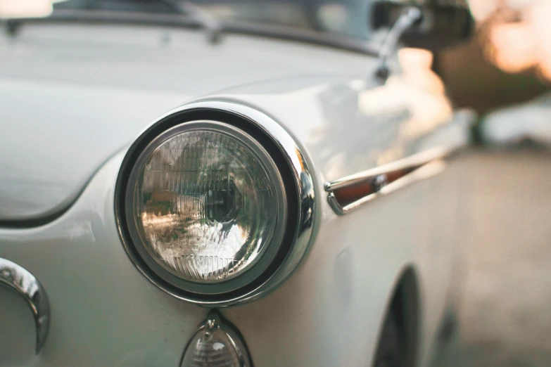 a silver car with the hood or light and headlight on