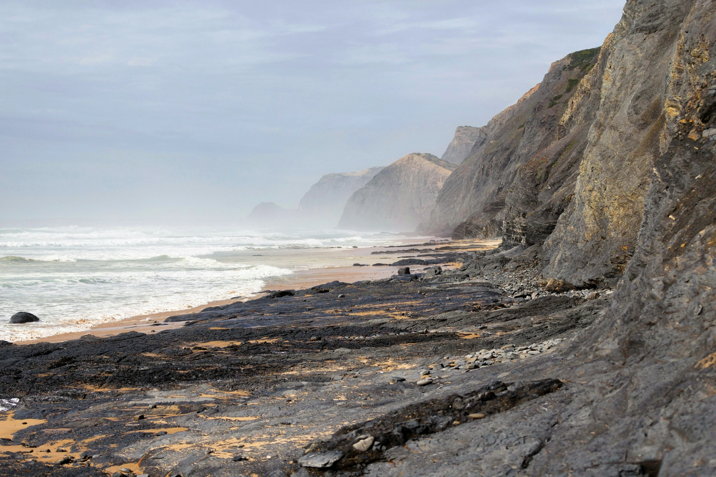 a view of the beach near some rocks