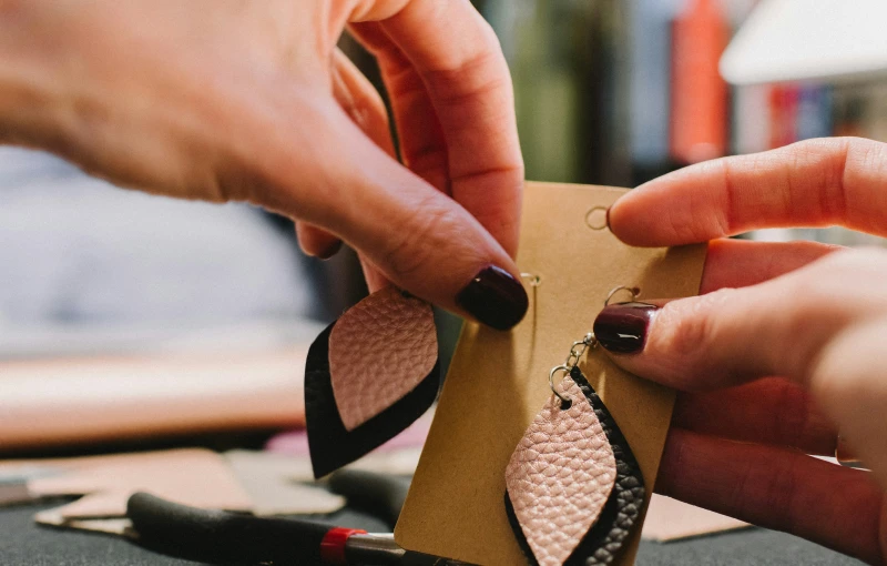 a close up of two hands working on some earring