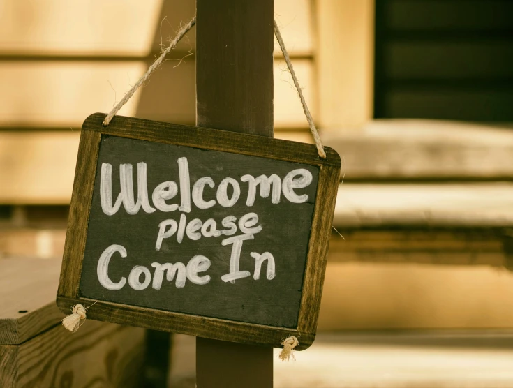an old fashioned welcome sign has words on it