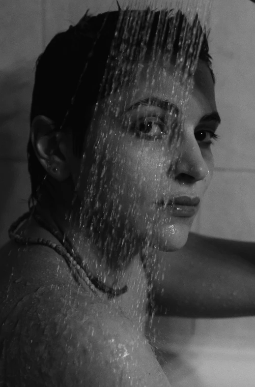 a woman sitting in the tub getting her wet