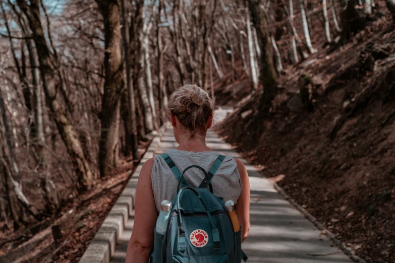 a person walking down a road in the woods