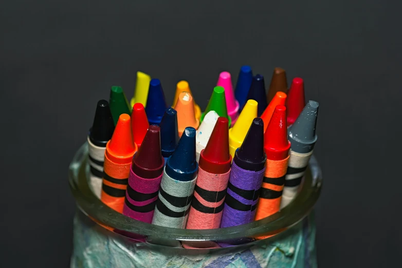 multiple crayons in color markers are seen in the jar