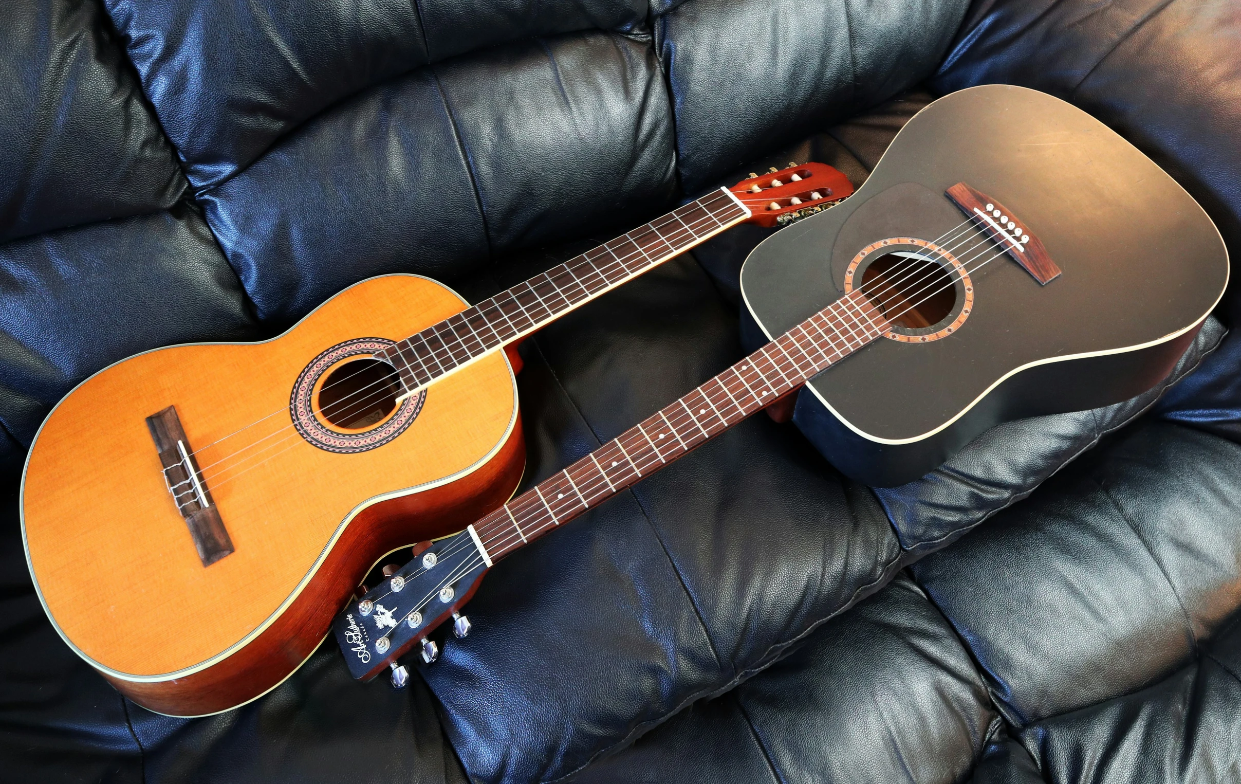 an ukulele sits on a coach in the sun