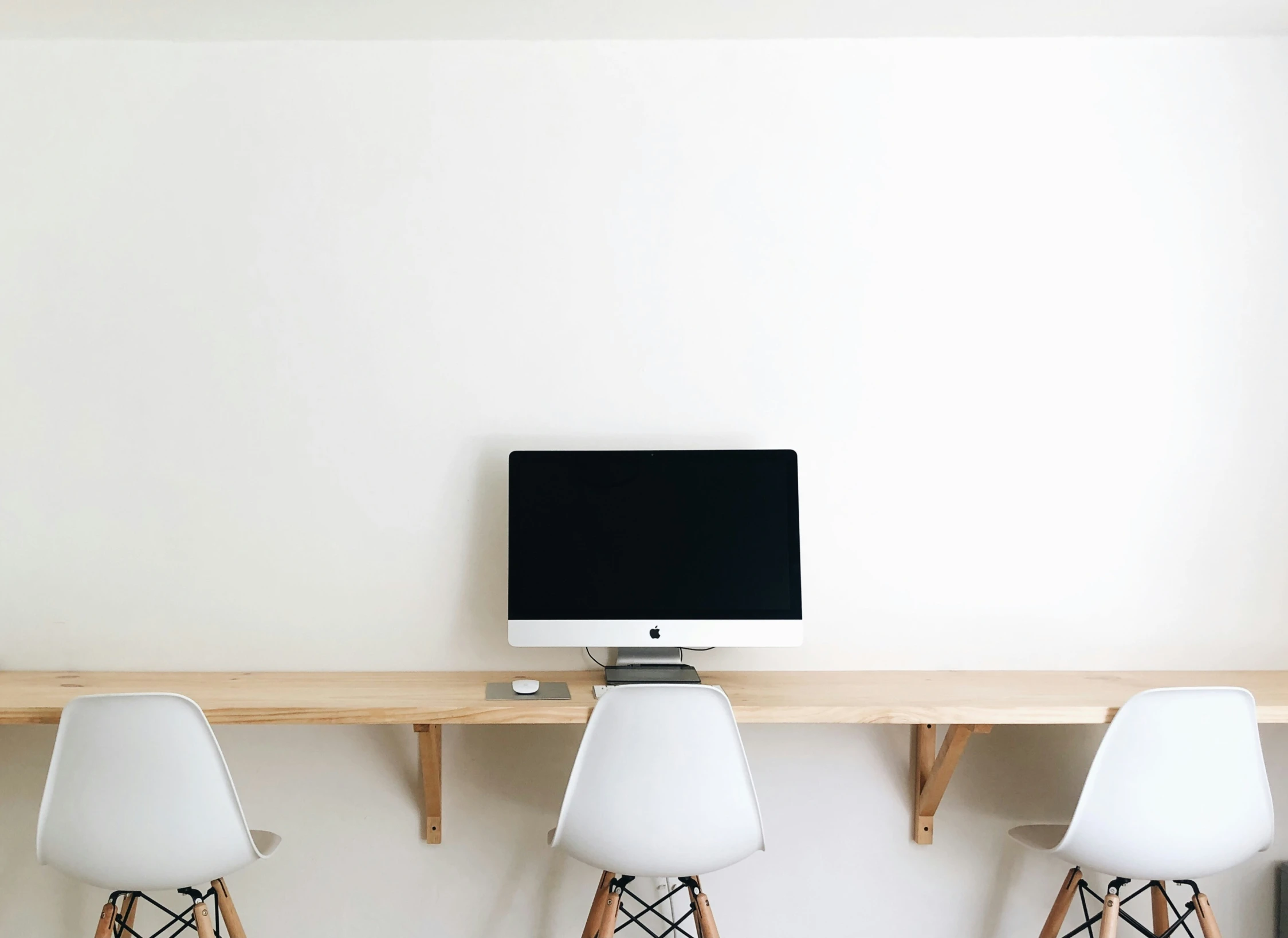 a wall mounted computer and a monitor sitting on top of a shelf