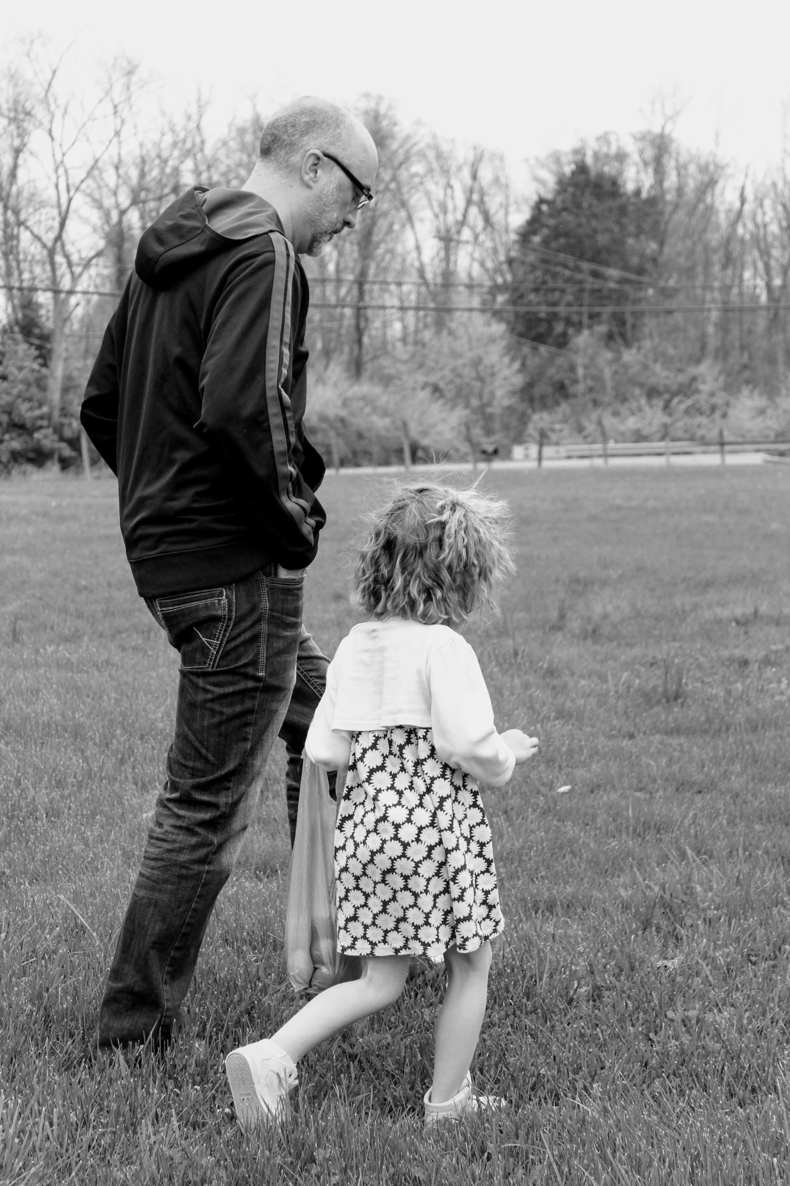 a  standing next to an older man on a lush green field