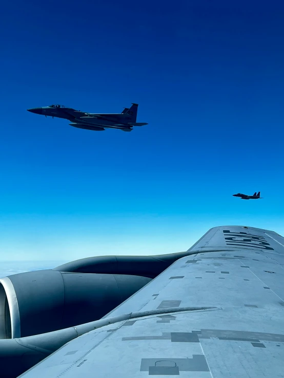 jet planes fly over the ocean below in the blue sky