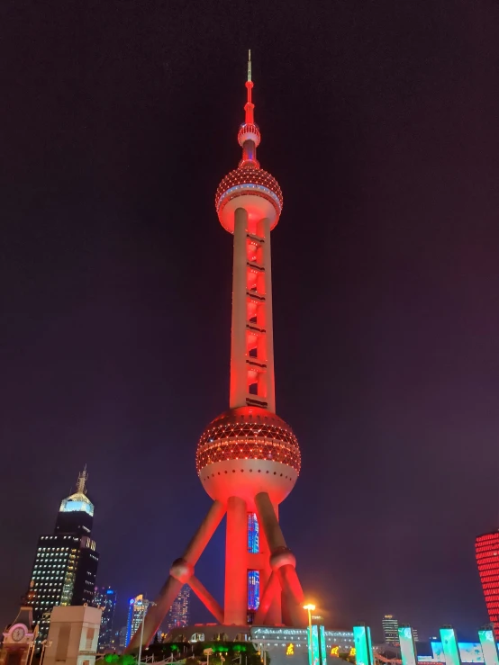 a very tall tower with a lit up red top