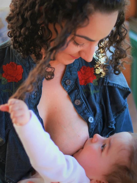 a woman holding her infant in the stomach while she licks it