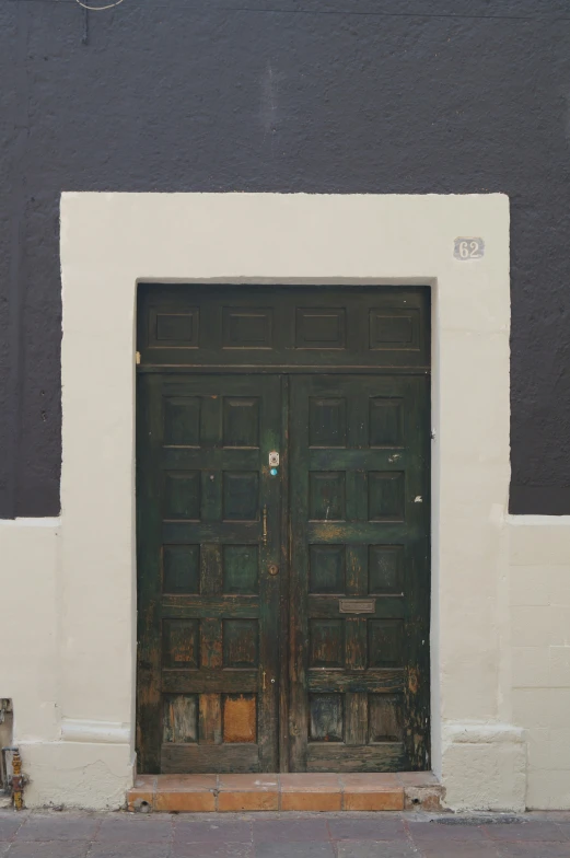 a black door and two benches in front of a building