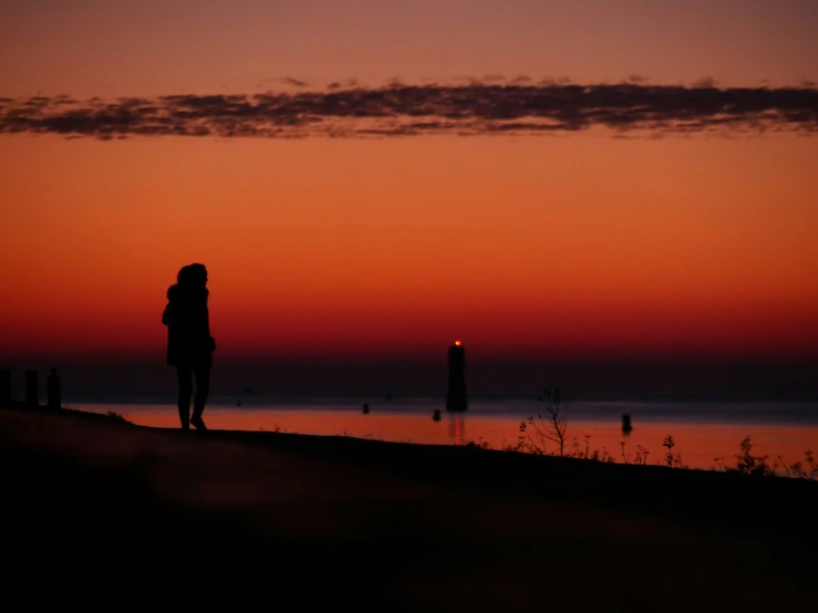 a person is standing in the distance near the ocean