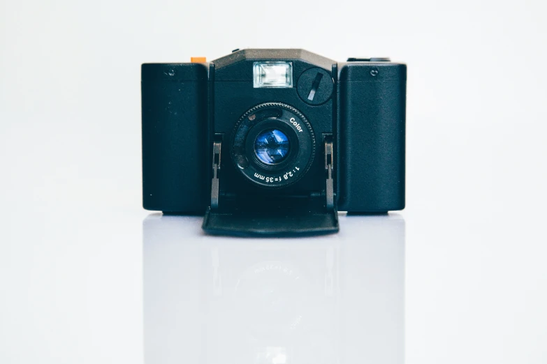 a black old fashioned camera sitting on top of a table