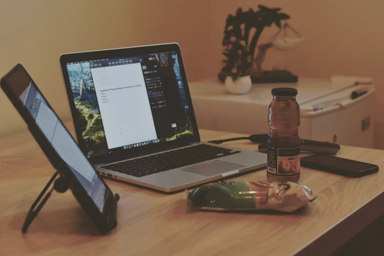 an open laptop computer sitting on top of a wooden desk