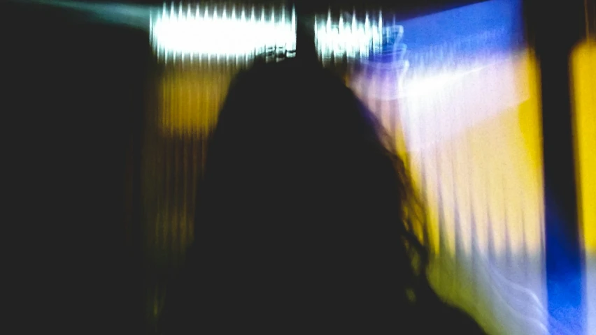 blurred view of a woman's back with bright lights