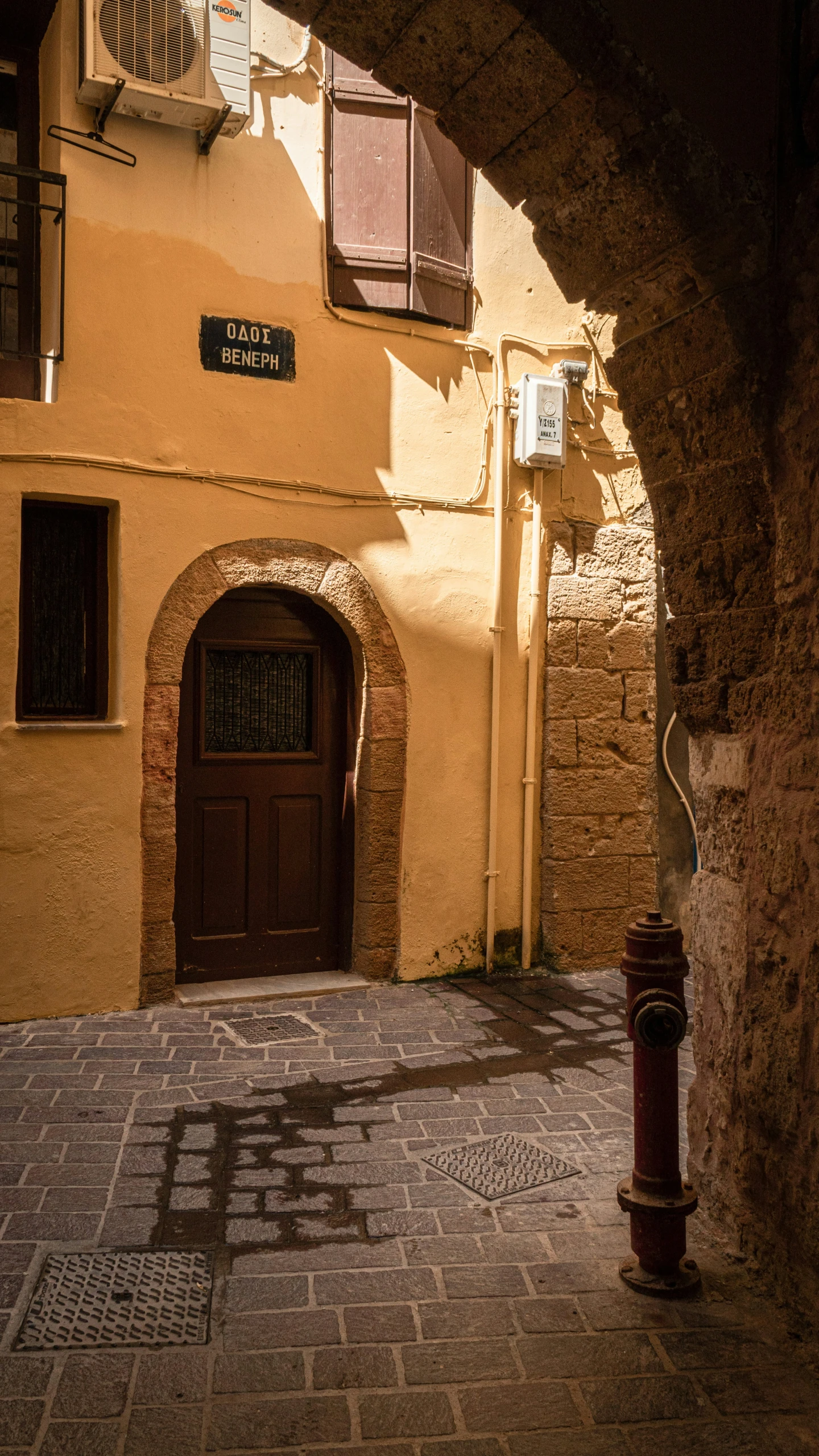 a cobblestone street next to a yellow building