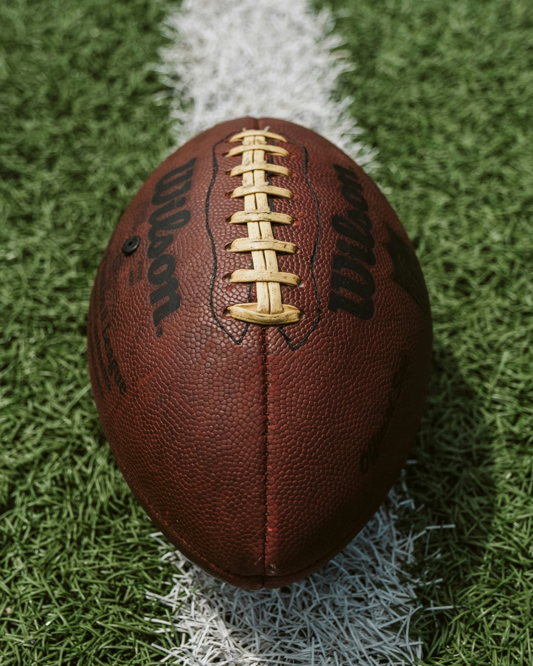 a football is sitting on the field in the grass