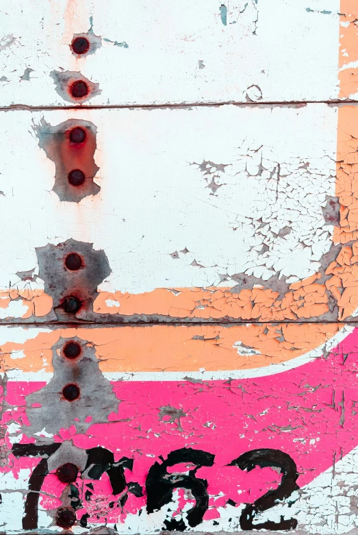 a close up s of some pink paint on a rusted building