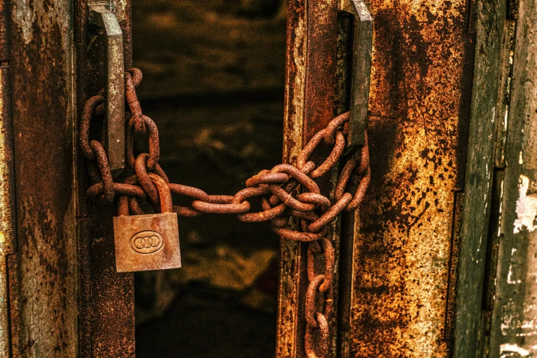 a rusty door with a padlock and chain in between