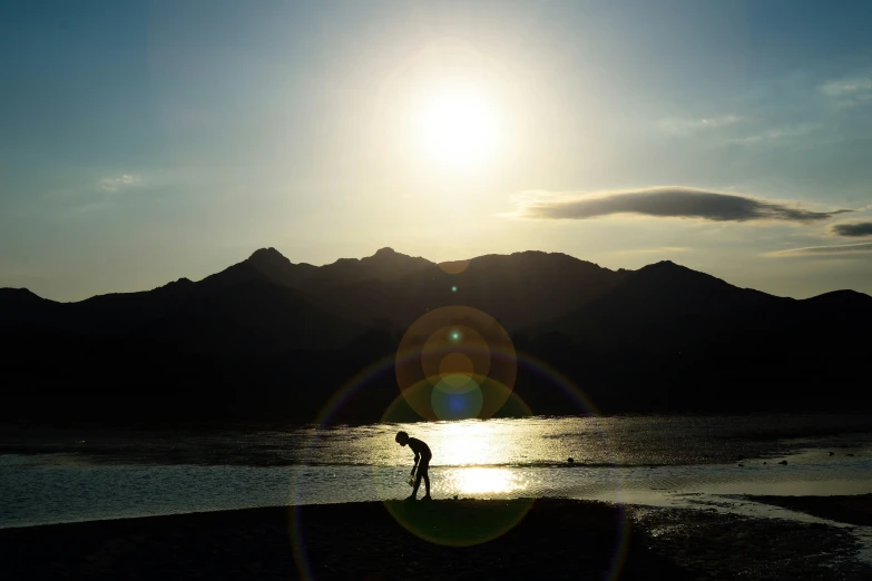 a person standing on top of a beach near mountains