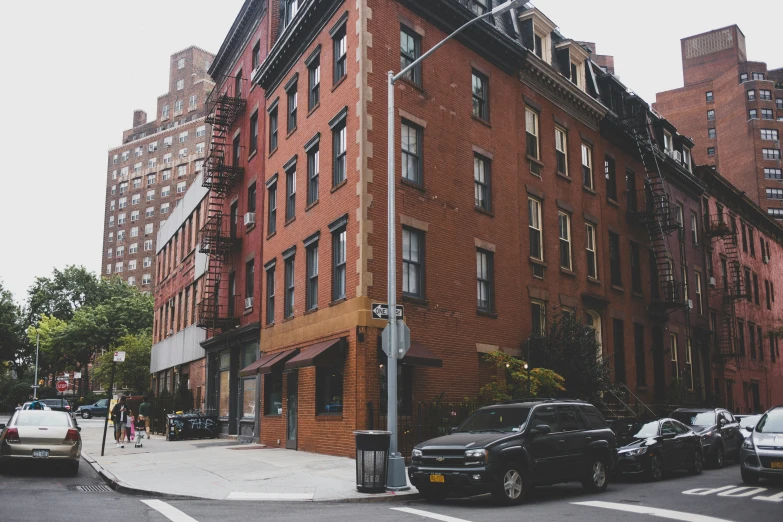 the corner of a street with several cars parked on the side of it