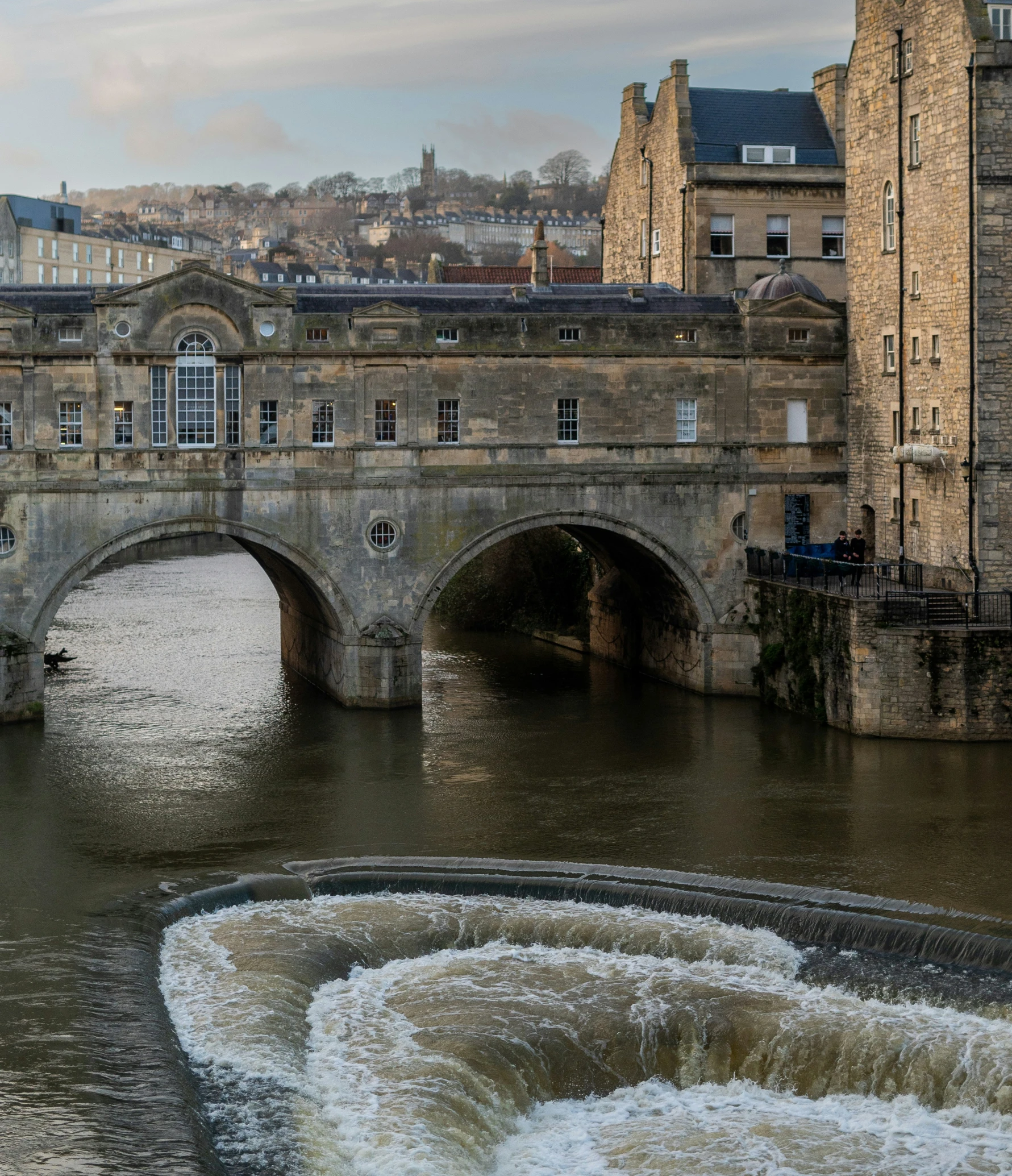 an old bridge over a river in a city