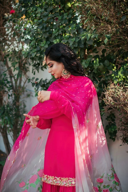 an indian woman in red standing on a hill