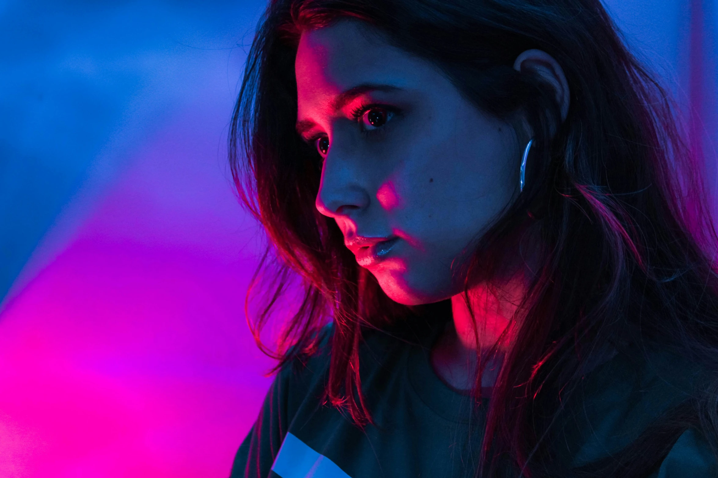 a woman standing in front of a wall with a light on her shirt