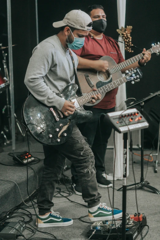 two people playing instruments in front of microphones