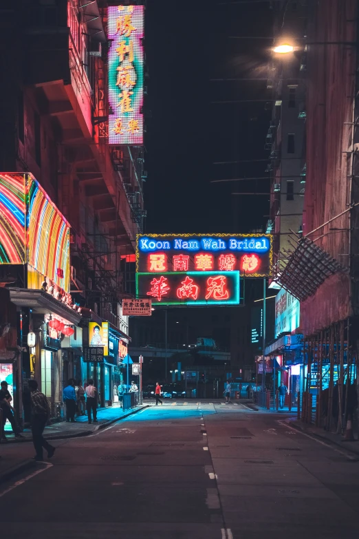 a street at night with colorful neon lights on the buildings and in the dark