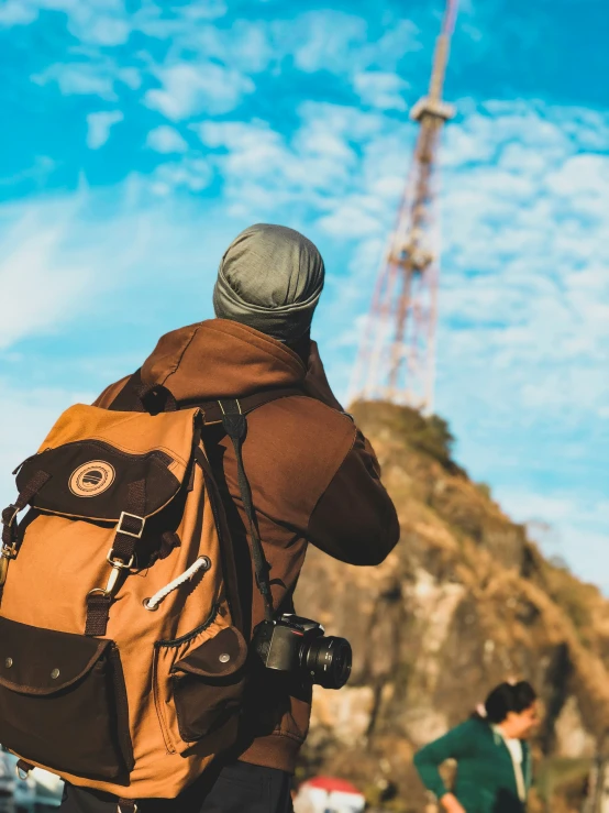 a person with a backpack on with the cell phone up to his ear