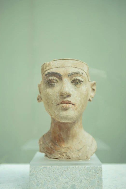 an ancient bust of a man wearing a hat