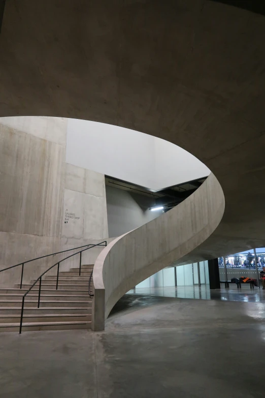 a curved stair is on top of a concrete wall