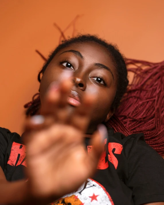 a woman in a black shirt holding a finger up