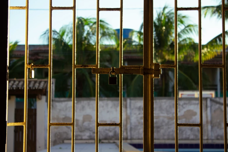 the bars of a  cell and buildings in the background